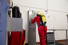 Feuerwehrmann in Overall mit Helm in der Atemschutzstrecke