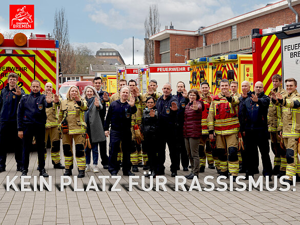 Mitarbeitende der Feuerwehr Bremen recken die linke Hand nach vorne, als Zeichen gegen Rassismus