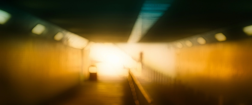 Verschwommenes Tunnelbild mit einem Lichtstrahl zum Tunnelausgang.