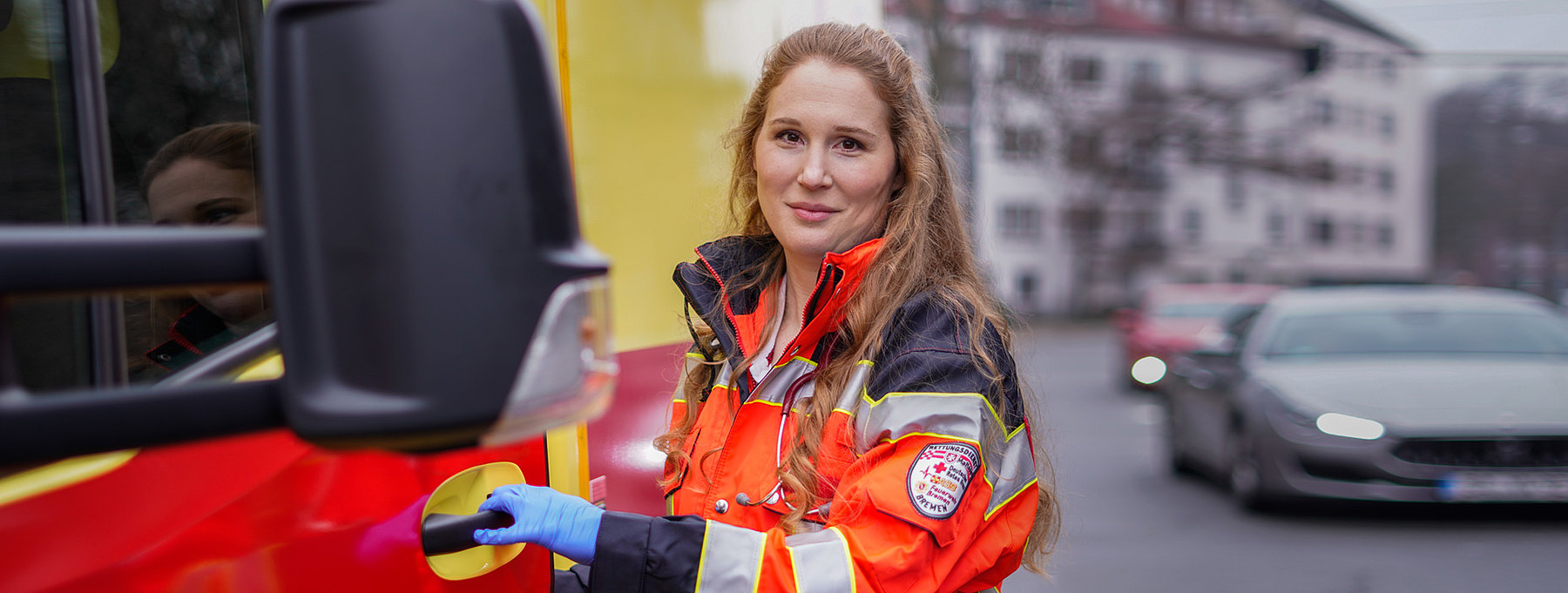 Notfallsanitäterin neben einem Rettungswagen