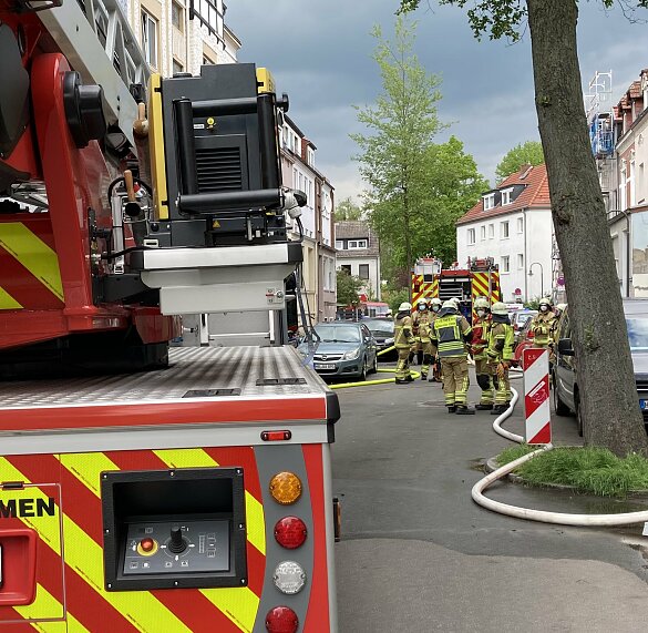 Ein Löschfahrzeug und eine Drehleiter bei einem Einsatz mit mehreren Feuerwehrleuten und ausgerollten Schläuchen