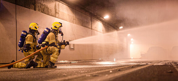 Zwei Feuerwehrbeamte bei loeschen eines Brandes