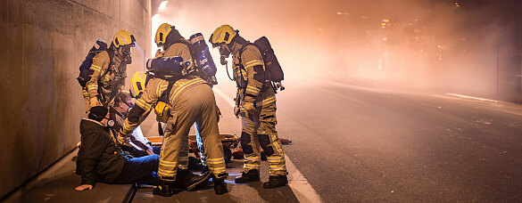 Mehrere Feuerwehrmänner beim Retten zweier Personen