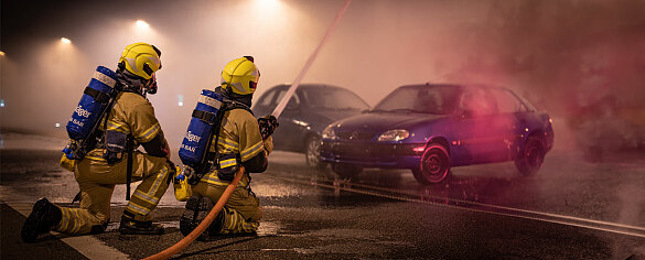 Zwei Feuerwehrmänner bei der PKW -Brandbekämpfung