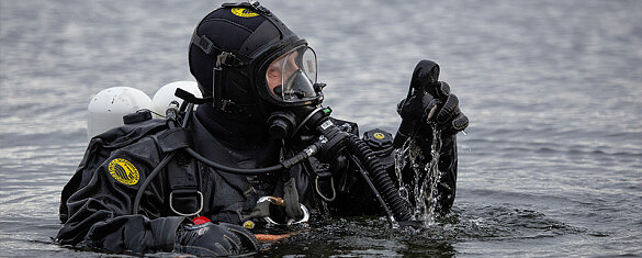 Ein Tauscher im Wasser bei der Kontrolle des Manometers