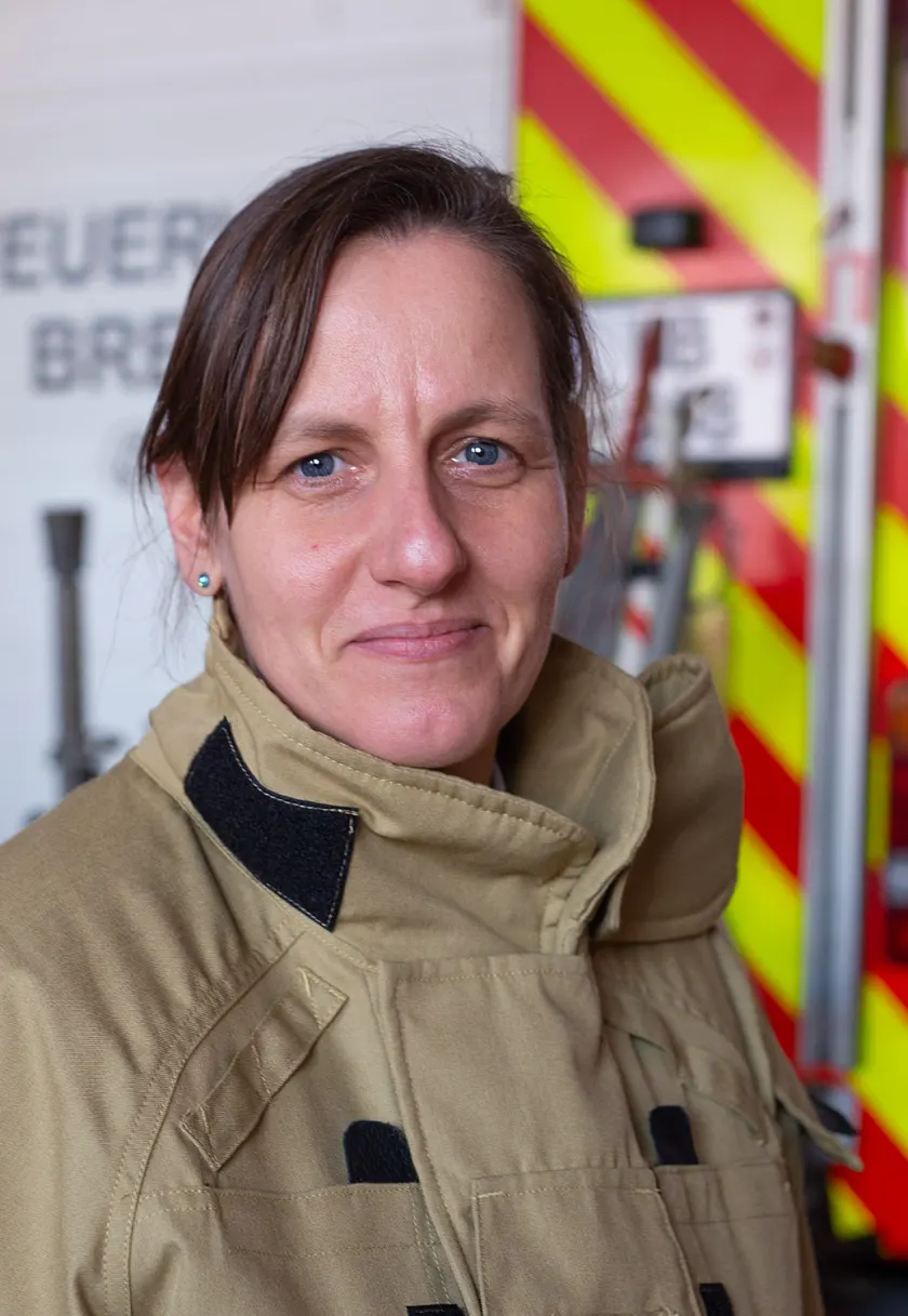 Eine Feuerwehrfrau vor einem Löschfahrzeug